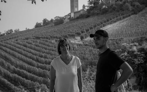 A landscape photo of Luigi Giordano's daughter, Laura, and her son, Matteo. They are seen standing in front of a large vineyard in the Luigi Giordano Winery in black and white.