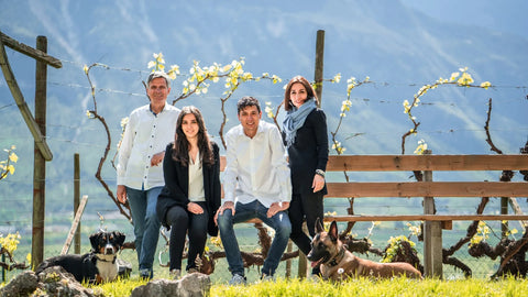 The Tiefenbrunner Family, sitting together on the bench at their winery field.
